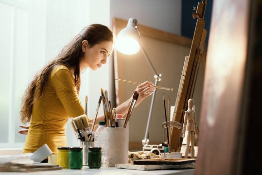 Creative woman painting on canvas in the studio