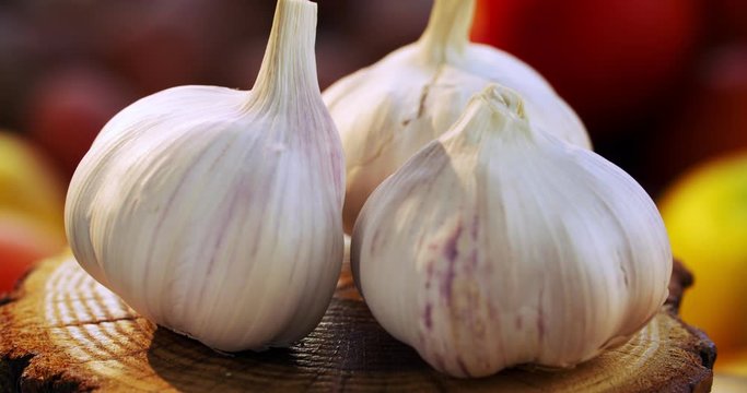 Whole garlic bulbs in the peel rotate around an axis