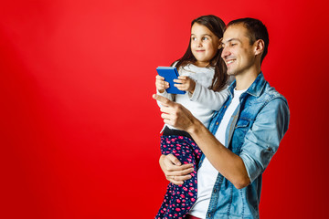 portrait of father and pretty daughter travelling together, Studio shot, red background