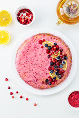 Cranberry pie with lemon on a white table. Top view, vertical orientation, closeup.
