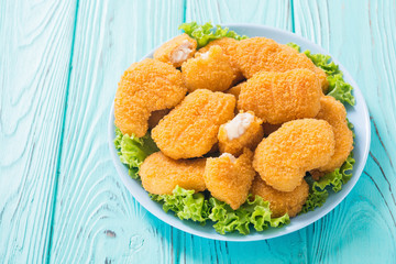 Chicken nuggets in plate on rustic background