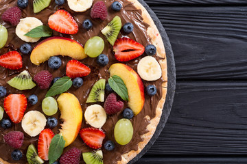 Fruit pizza with nut nougat cream , fruit and berries