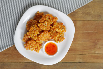 Deep fried Corn cake on white plate with sauce
