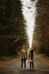 Fototapeta premium young man and girl stand on a forest road and hold hands