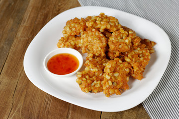 Deep fried Corn cake on white plate with sauce