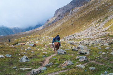 Fototapeta na wymiar Anonymous people riding horses in the mountains