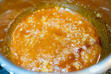 Close up shot of heating the sugar in a pan to make caramel