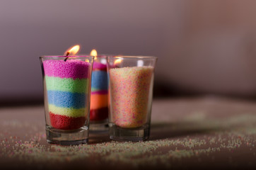 Homemade candles from colored granulated wax in a glasses.