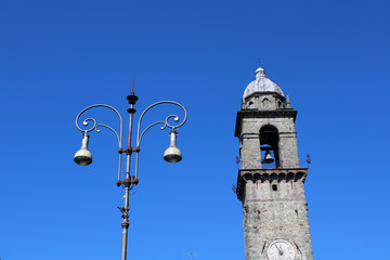 Fototapeta na wymiar Lampione con campanile e cielo azzurro