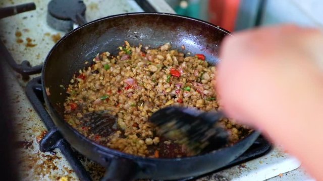 Asian women cooking Thai food fried pork and garlic prepare to cook pad kla plao.