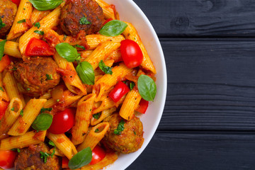 Italian penne pasta with meatballs and tomatoes