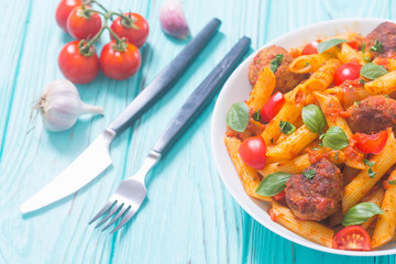 Italian penne pasta with meatballs and tomatoes