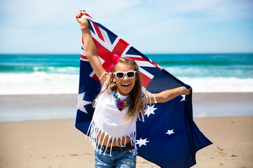 Little girl raises hands with Australian flag celebrating Australia Day	