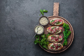 Roast beef on crusty bread with mayo and rocket, copy space