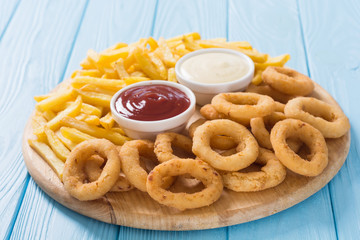 French fries and onion rings with sauces