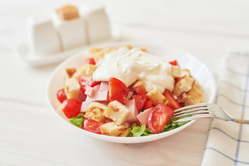fresh high-calorie salad with cheese, herbs, toast and ham