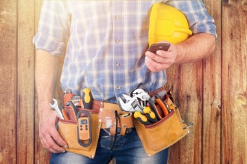 Young man worker with tool belt and helmet