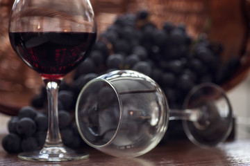 A glass of fragrant red wine and bunches of blue grapes