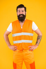 Its time to work a harder. Happy hipster on yellow background. Bearded hipster smiling in work clothes. Hipster construction worker with long beard and mustache. Builder or miner in hipster style