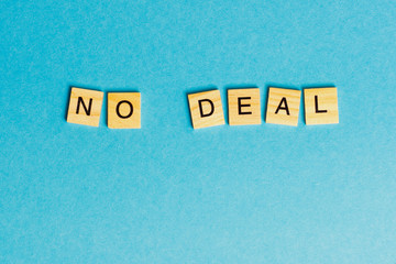 the English words - no deal - laid with wooden letters on a blue background