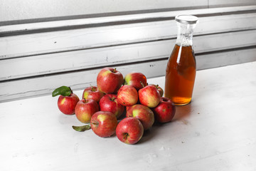 apple juice in glass bottle  and apples on Woden Provence table