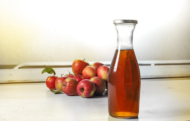 apple juice in glass bottle  and apples on Woden Provence table