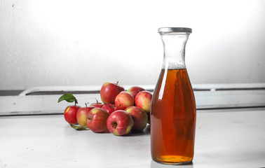 apple juice in glass bottle  and apples on Woden Provence table