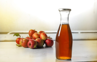 apple juice in glass bottle  and apples on Woden Provence table