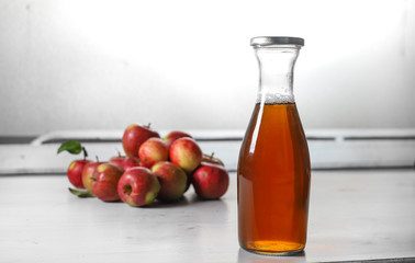 apple juice in glass bottle  and apples on Woden Provence table