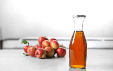 apple juice in glass bottle  and apples on Woden Provence table
