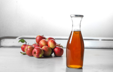 Fototapeta na wymiar apple juice in glass bottle and apples on Woden Provence table