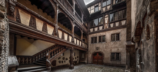 Obraz premium Ancient patio with wooden staircase in old timber-framing rich house XV century