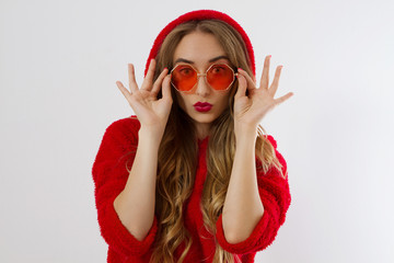 Happy, shock, excited woman face closeup. Girl in bright red hoodie autumn clothes red sunglasses isolated. white background, copy space. Beautiful female surprised, cheerful. model Fun time