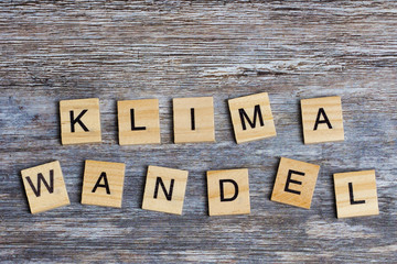 Naklejka premium the German word means climate change in English, laid with wooden capital letters on wooden background