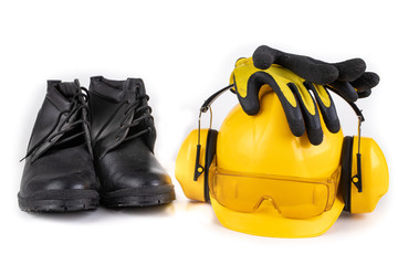 Helmet, boots and work gloves on a white table. Workwear for the production worker.