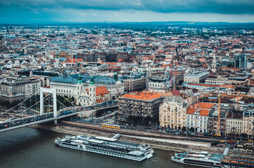 Obraz premium Cityscape of Budapest, Hungary, panoramic top view. Danube river with cruise ships and old town. Landmark famous place. Cloudy weather. Soft focus. Old historic buildings. Travelling to Europe