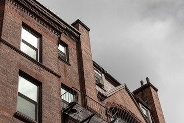 Top edge of old brownstone apartments on a cloudy way, horizontal aspect