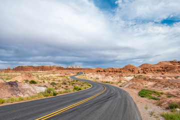 Wide angle view of winding road and red sandstone rock formations desert landscape in Goblin Valley State Park in Utah summer