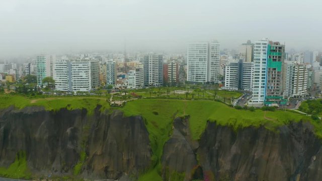 Aerial view of Malecon of Miraflores in foggy and cloudy day. Low altitude fog covers the buildings. Lima City, Peru