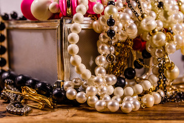 Aluminium case full of different jewelry on wooden table