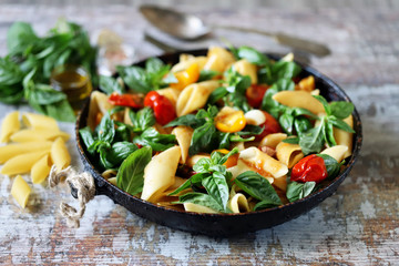 One pan vegan pasta. Appetizing pasta with tomatoes, basil and spices. Selective focus. Macro.