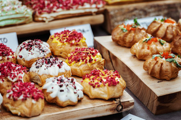 Colourful small cakes placed on a wood plank.