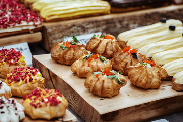 Colourful small cakes placed on a wood plank.