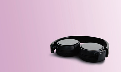 Black headphones on a pastel pink background. The concept of creating and listening to music. Comfortable headphones for listening to music. Creating sounds and listening to the foundations.