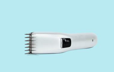 Hair clipper on a pastel blue background. The concept of cutting, improving the appearance. Going to the hairdresser, cutting hair at home. Taking care of appearance.