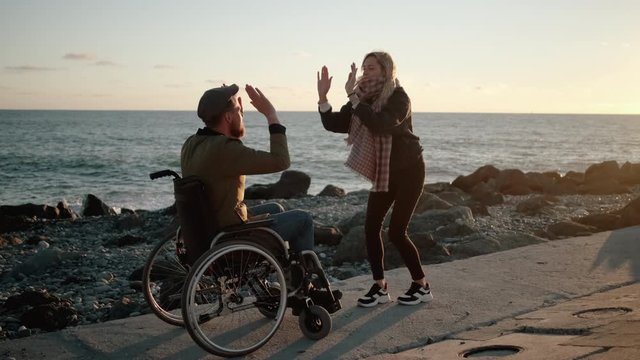Disabled man with cheerful woman friend outdoors