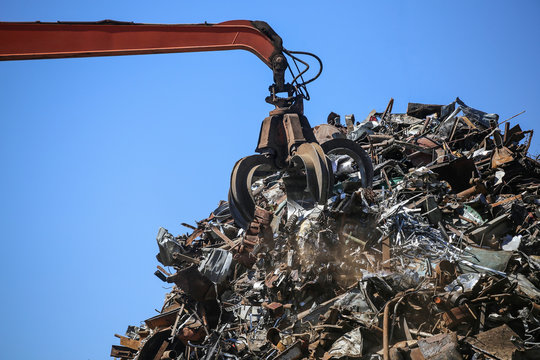 Close up industrial claw machine, move scrap metal in the landfill. Excavator arm, claw crane.