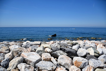 Fototapeta na wymiar Seascape view with rocky beach in the foreground
