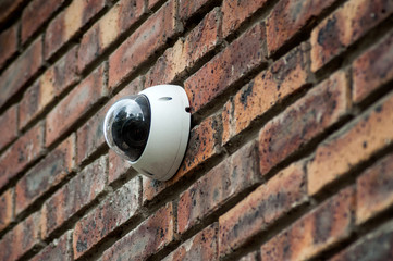 security camera on brick wall facade