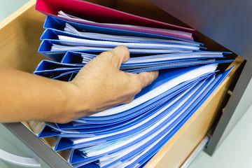 Hand of Man Search files document in a file cabinet in work office